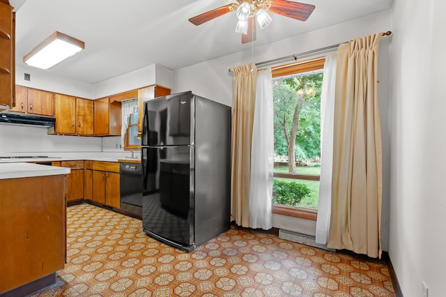 76 Taft St, Battle Creek, MI 49014 - kitchen featuring black appliances, under cabinet range hood, brown cabinets, light countertops, and a ceiling fan