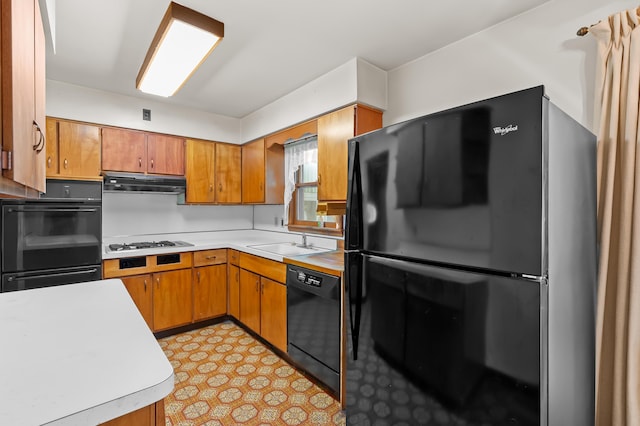 76 Taft St, Battle Creek, MI 49014 - kitchen featuring black appliances, light countertops, under cabinet range hood, and brown cabinetry