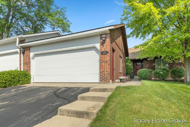 6305 Greenway Dr SE Unit 51, Grand Rapids, MI 49546 - view of front of house featuring brick siding, a front yard, an attached garage, and asphalt driveway