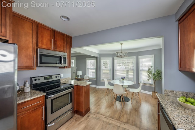 1416 N Alexander Ave, Royal Oak, MI 48067 - kitchen with appliances with stainless steel finishes, light wood finished floors, a chandelier, light stone counters, and recessed lighting