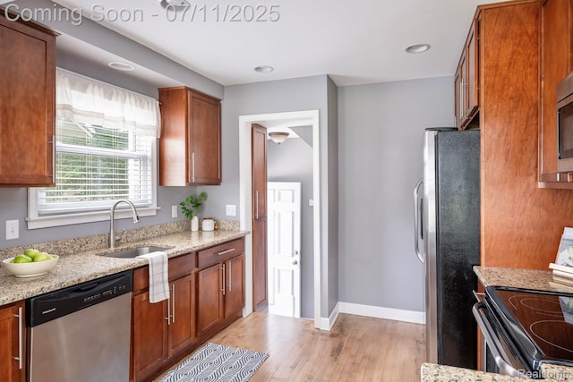 1416 N Alexander Ave, Royal Oak, MI 48067 - kitchen with stainless steel appliances, light wood-style flooring, light stone counters, and brown cabinets