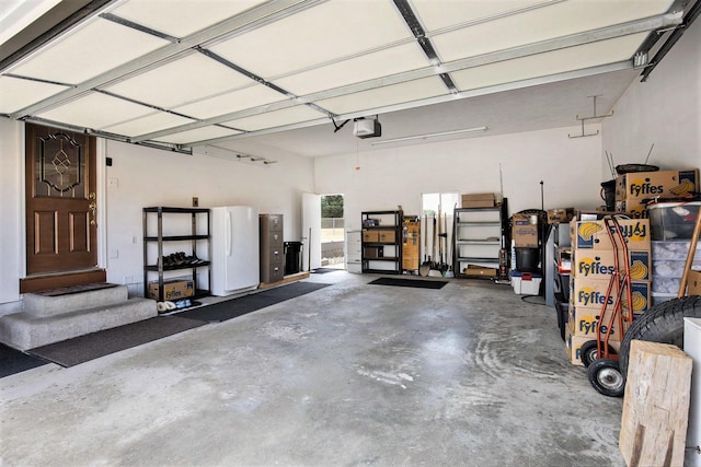 236 Jeffrey St NE, Cedar Springs, MI 49319 - garage featuring a garage door opener and freestanding refrigerator