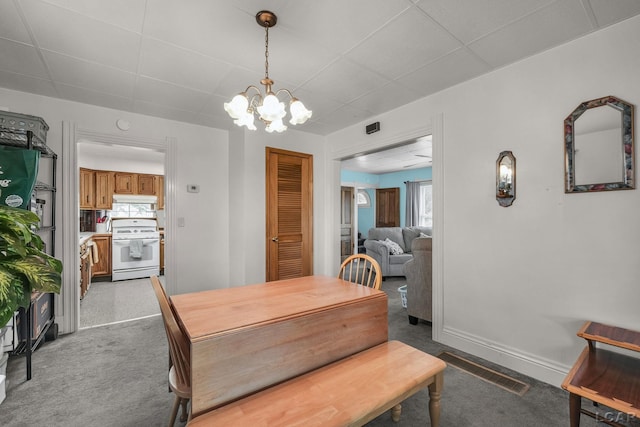 318 E Adrian St, Blissfield, MI 49228 - carpeted dining space with a chandelier and a drop ceiling