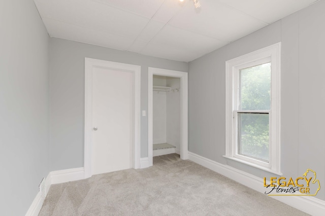 445 Prince St SE, Grand Rapids, MI 49507 - unfurnished bedroom with carpet flooring, multiple windows, a drop ceiling, and a closet