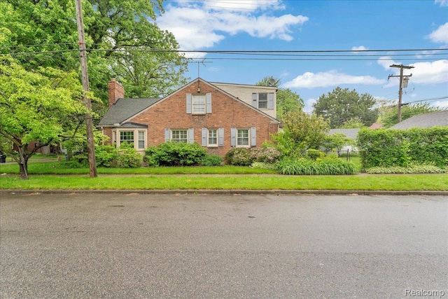 4800 Bishop St, Detroit, MI 48224 - traditional-style house with brick siding, a chimney, and a front lawn