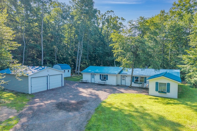 1051 Vallado Dr, Weidman, MI 48893 - view of front of house with a garage, a front lawn, a storage unit, and a metal roof
