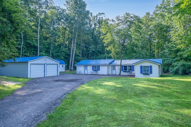 1051 Vallado Dr, Weidman, MI 48893 - single story home with a detached garage, an outdoor structure, a front yard, and a metal roof
