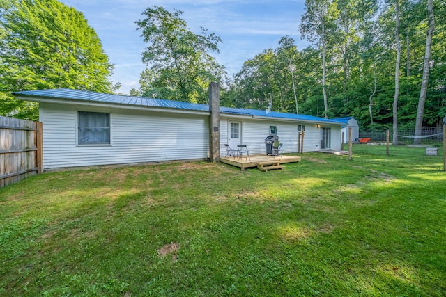 1051 Vallado Dr, Weidman, MI 48893 - back of house with a wooden deck, a storage shed, a fenced backyard, and a metal roof