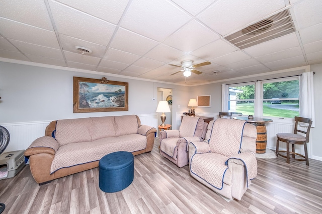 1051 Vallado Dr, Weidman, MI 48893 - living area featuring a drop ceiling, wood finished floors, a wainscoted wall, a ceiling fan, and ornamental molding
