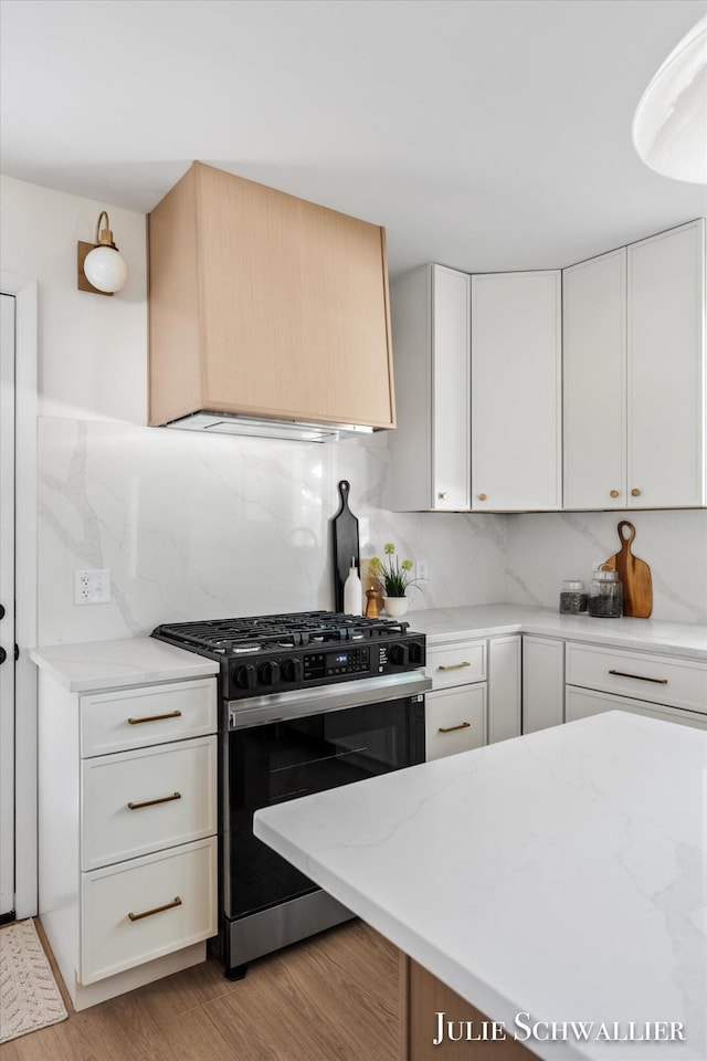 751 Old Gate Rd NW, Grand Rapids, MI 49504 - kitchen featuring gas range, backsplash, light stone countertops, light wood finished floors, and white cabinets