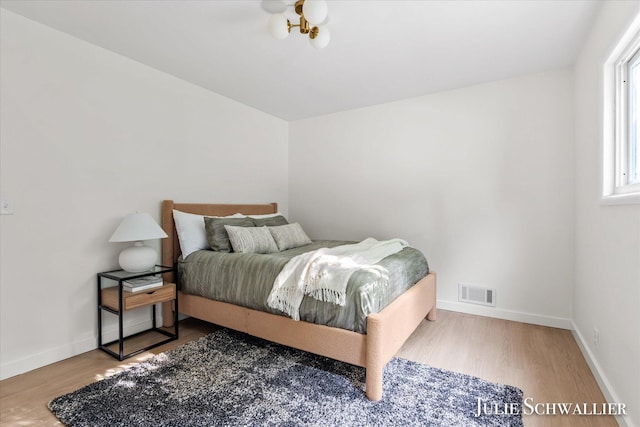 751 Old Gate Rd NW, Grand Rapids, MI 49504 - bedroom featuring wood finished floors and a chandelier