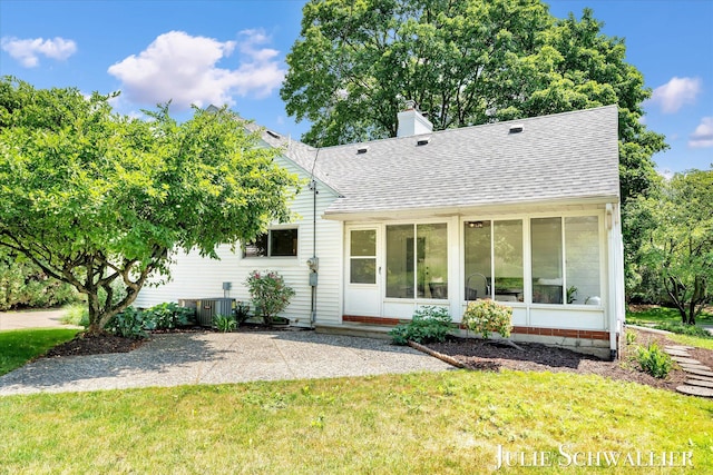 751 Old Gate Rd NW, Grand Rapids, MI 49504 - view of front of property with a shingled roof, a sunroom, a chimney, and a front yard
