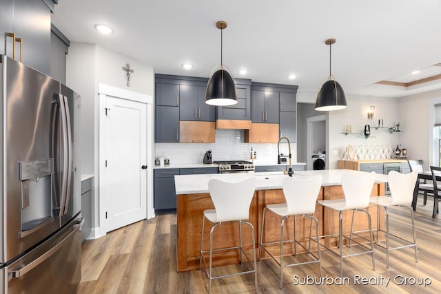 8056 Tramway Dr SW, Byron Center, MI 49315 - kitchen with stainless steel fridge, washer / clothes dryer, light wood-style floors, light countertops, and backsplash