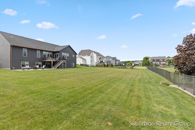 8056 Tramway Dr SW, Byron Center, MI 49315 - view of yard with stairs, a wooden deck, a residential view, and a patio area