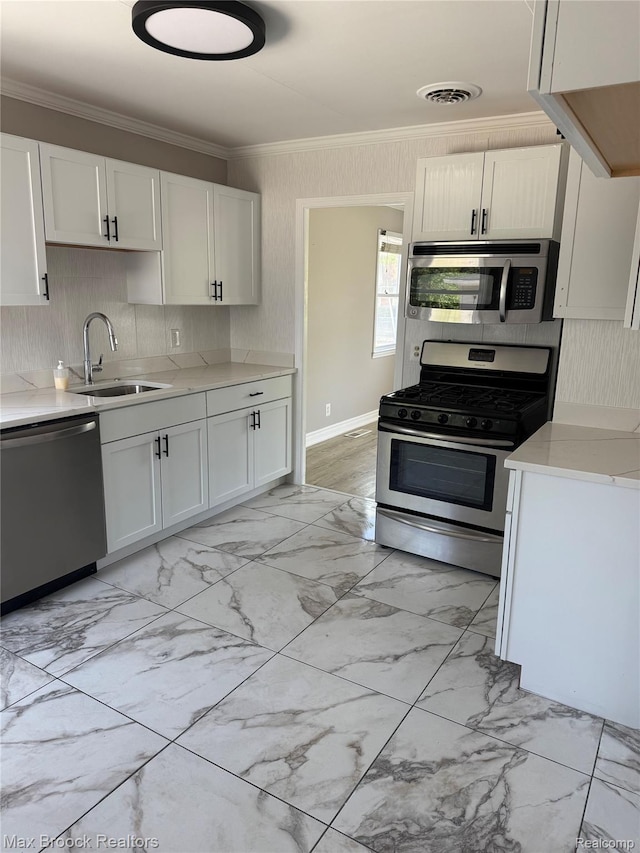 147 Euclid St, Mount Clemens, MI 48043 - kitchen featuring appliances with stainless steel finishes, crown molding, light marble finish floors, light countertops, and white cabinetry