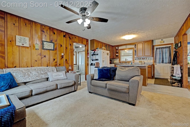 1962 Lake Pointe Dr, Ortonville, MI 48462 - living room with ceiling fan, a textured ceiling, wooden walls, and light colored carpet