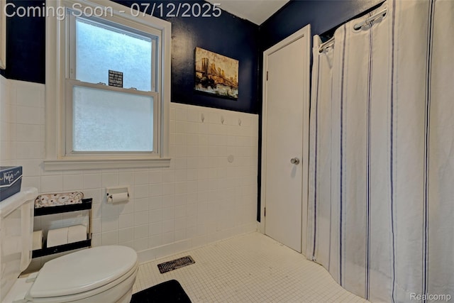 1962 Lake Pointe Dr, Ortonville, MI 48462 - bathroom with tile walls, curtained shower, tile patterned flooring, and a wainscoted wall
