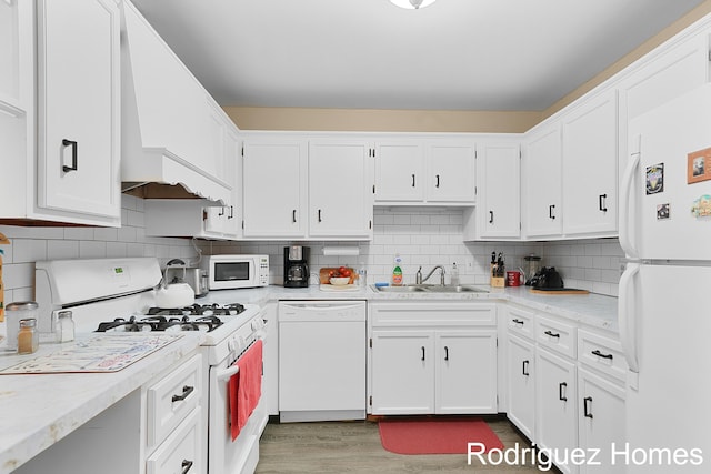 2106 Cranbrook Dr NE, Grand Rapids, MI 49505 - kitchen with white appliances, premium range hood, white cabinetry, and tasteful backsplash