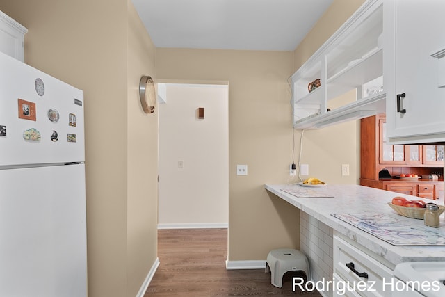 2106 Cranbrook Dr NE, Grand Rapids, MI 49505 - kitchen featuring freestanding refrigerator, wood finished floors, and white cabinetry