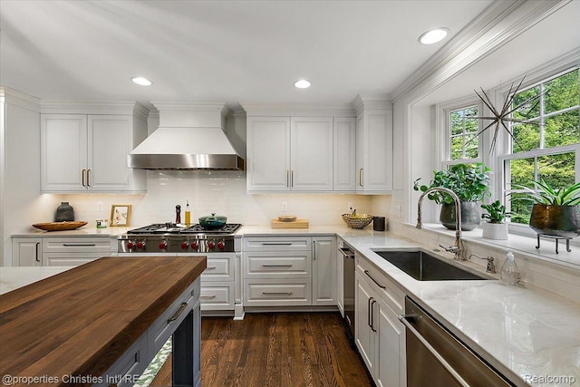 586 Fairfax St, Birmingham, MI 48009 - kitchen with custom exhaust hood, stainless steel appliances, white cabinets, light stone countertops, and recessed lighting