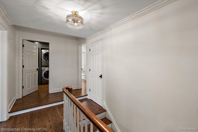 586 Fairfax St, Birmingham, MI 48009 - hallway featuring stacked washer and clothes dryer, dark wood finished floors, a chandelier, and crown molding