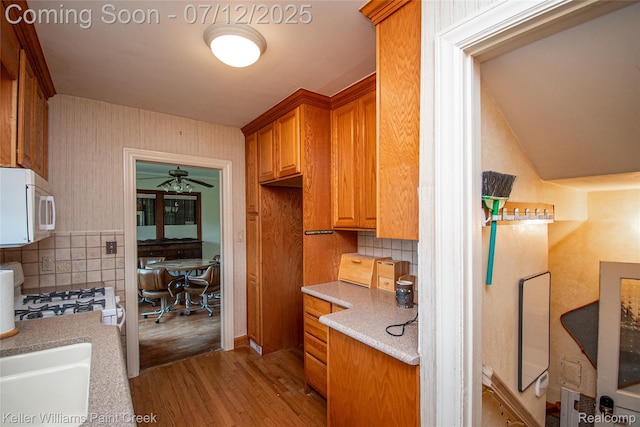 20525 30 Mile Rd, Ray, MI 48096 - kitchen featuring white microwave, wood finished floors, range, a ceiling fan, and backsplash