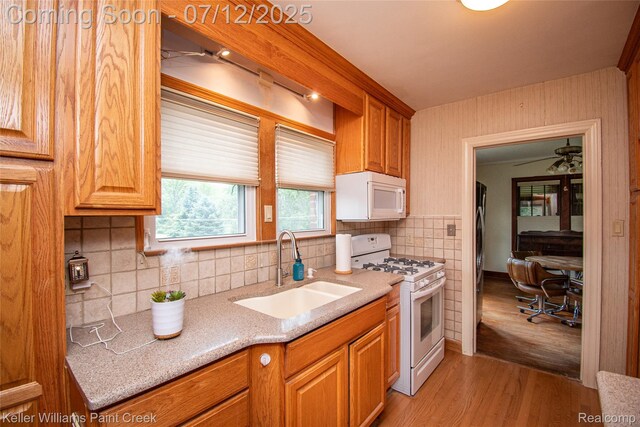20525 30 Mile Rd, Ray, MI 48096 - kitchen with white appliances, light wood-type flooring, decorative backsplash, and brown cabinetry