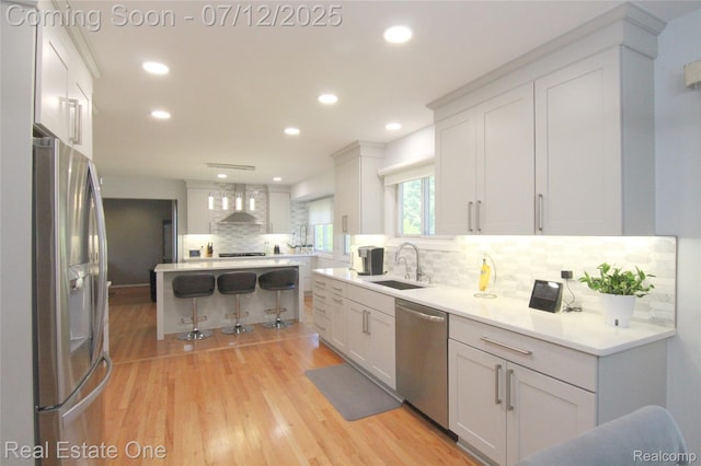 33234 Walnut Ln, Farmington Hills, MI 48334 - kitchen with appliances with stainless steel finishes, tasteful backsplash, light wood-style flooring, wall chimney exhaust hood, and recessed lighting