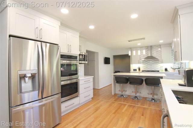 33234 Walnut Ln, Farmington Hills, MI 48334 - kitchen with appliances with stainless steel finishes, wall chimney range hood, decorative backsplash, light countertops, and white cabinets