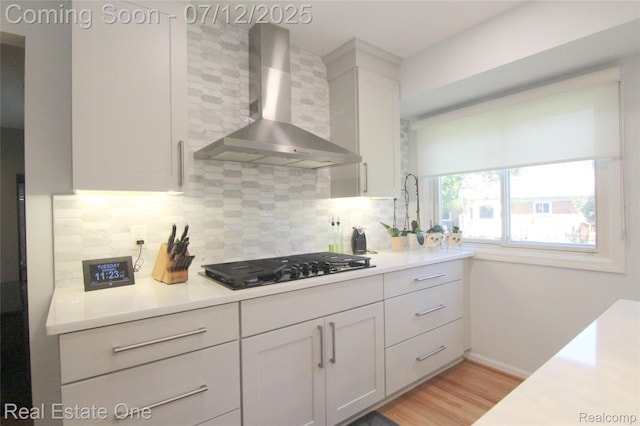 33234 Walnut Ln, Farmington Hills, MI 48334 - kitchen featuring wall chimney exhaust hood, black gas stovetop, decorative backsplash, and light countertops