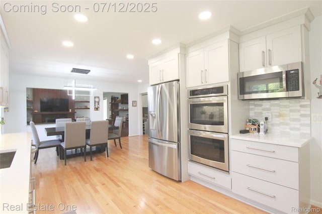 33234 Walnut Ln, Farmington Hills, MI 48334 - kitchen with stainless steel appliances, decorative backsplash, light countertops, recessed lighting, and white cabinetry