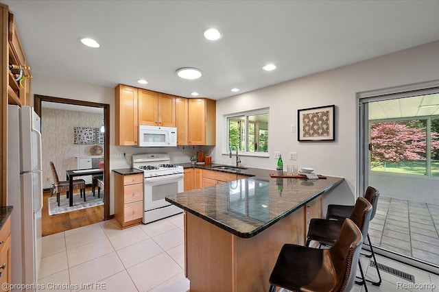 30700 Marimoor St, Beverly Hills, MI 48025 - kitchen featuring white appliances, a peninsula, a breakfast bar area, light tile patterned floors, and recessed lighting