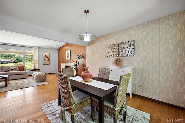 30700 Marimoor St, Beverly Hills, MI 48025 - dining area featuring wallpapered walls, wood finished floors, a fireplace, and an accent wall