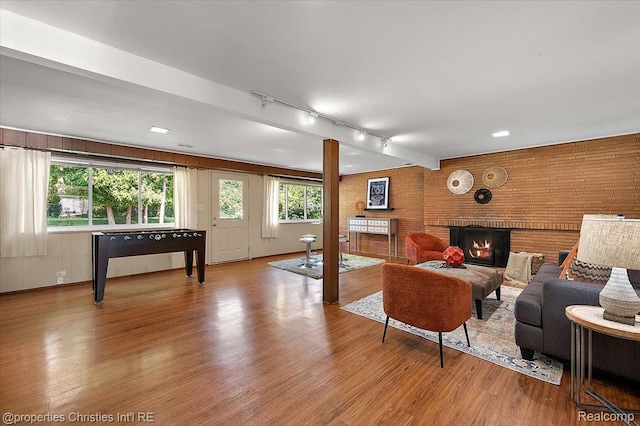 30700 Marimoor St, Beverly Hills, MI 48025 - living room with rail lighting, wood finished floors, and a brick fireplace