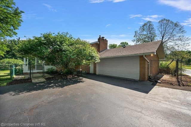 30700 Marimoor St, Beverly Hills, MI 48025 - view of front of home featuring a gate, a garage, brick siding, and a chimney