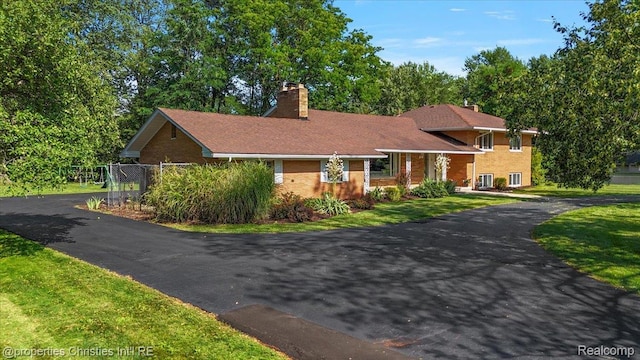 30700 Marimoor St, Beverly Hills, MI 48025 - tri-level home with a chimney, brick siding, and driveway