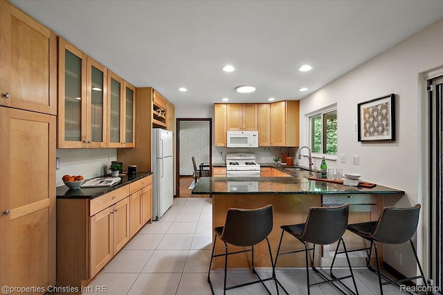 30700 Marimoor St, Beverly Hills, MI 48025 - kitchen with white appliances, a peninsula, a kitchen bar, glass insert cabinets, and light tile patterned floors