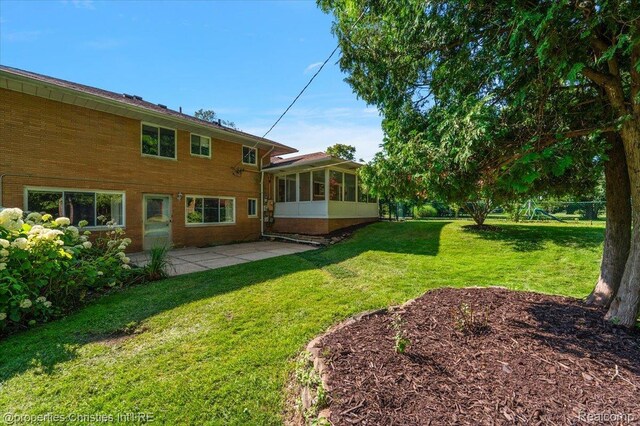 30700 Marimoor St, Beverly Hills, MI 48025 - view of grassy yard featuring a patio and a sunroom