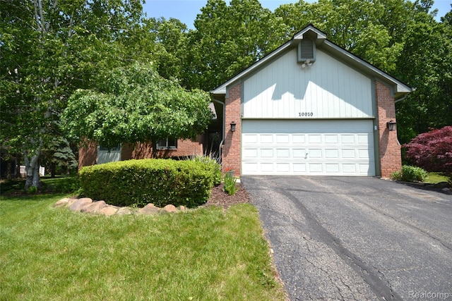 10010 Orchard Ridge Ct, Holly, MI 48442 - view of front of house with asphalt driveway, a garage, brick siding, and a front lawn