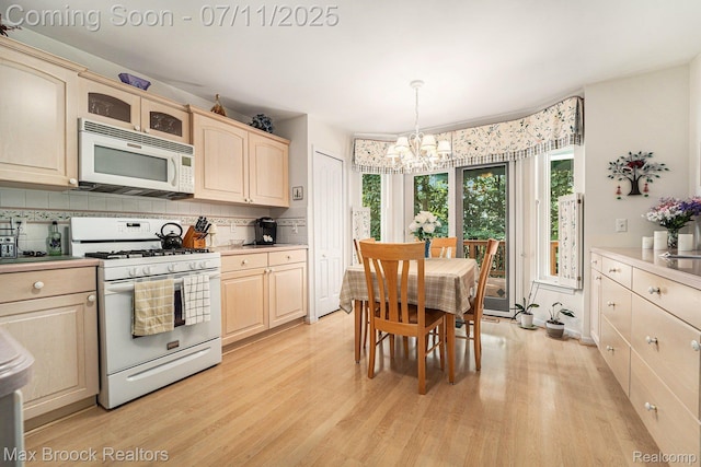 648SHADYMAPLE Shady Maple Dr Unit 16, Wixom, MI 48393 - kitchen with white appliances, a chandelier, light wood-style flooring, backsplash, and light countertops