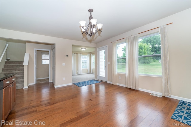 750 Dewars St, Howell, MI 48843 - unfurnished dining area featuring hardwood / wood-style flooring, a chandelier, and stairway