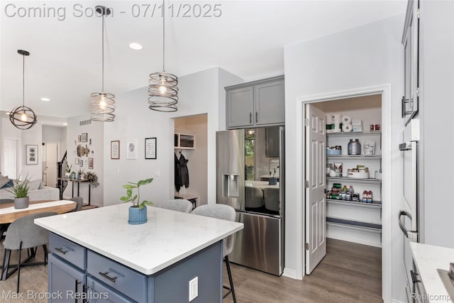 460 Lake Manitou Trl, Oxford, MI 48371 - kitchen with stainless steel fridge with ice dispenser, a breakfast bar, light wood-type flooring, a kitchen island, and hanging light fixtures