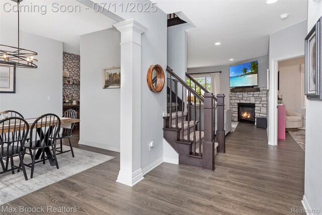 460 Lake Manitou Trl, Oxford, MI 48371 - stairs with wood finished floors, a fireplace, a chandelier, recessed lighting, and decorative columns