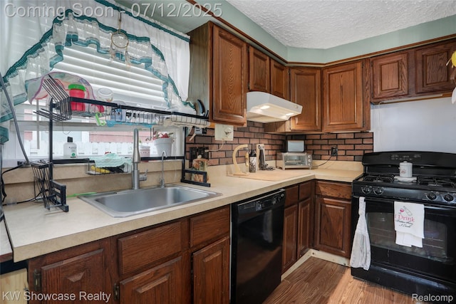 4313 S Dearborn St, Melvindale, MI 48122 - kitchen featuring black appliances, under cabinet range hood, light countertops, wood finished floors, and a textured ceiling