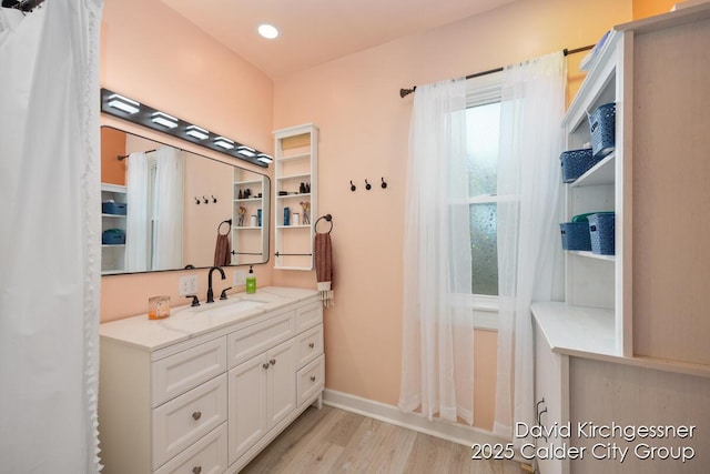 122 Dwight Ave SE, Grand Rapids, MI 49506 - bathroom with wood finished floors, vanity, and recessed lighting