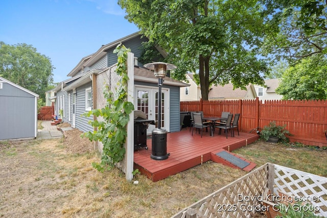 122 Dwight Ave SE, Grand Rapids, MI 49506 - back of house featuring a deck, a fenced backyard, outdoor dining space, a storage unit, and french doors