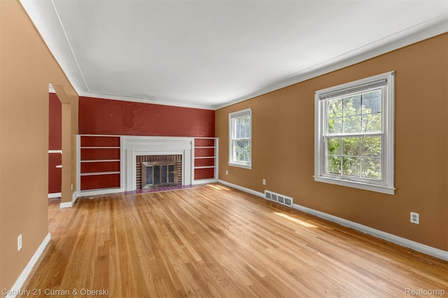 711 N Highland St, Dearborn, MI 48128 - unfurnished living room with light wood-style flooring and a brick fireplace