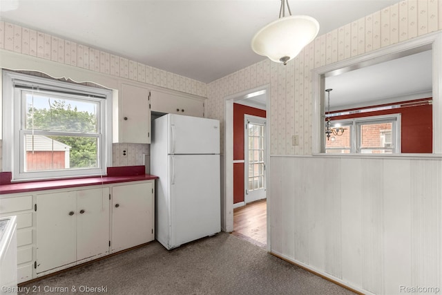 711 N Highland St, Dearborn, MI 48128 - kitchen featuring freestanding refrigerator, wallpapered walls, carpet flooring, and a chandelier