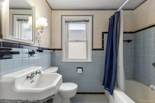 711 N Highland St, Dearborn, MI 48128 - bathroom with tile walls, shower / bath combination with curtain, a wainscoted wall, wallpapered walls, and tile patterned flooring