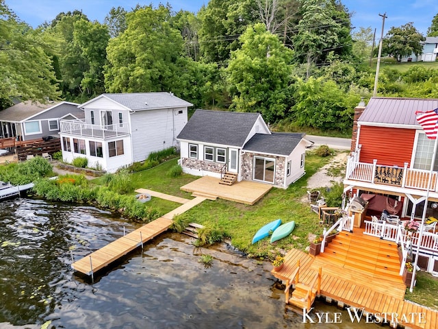 12230 Mac Dr NE, Belding, MI 48809 - rear view of house with stone siding, a yard, an outdoor structure, and a deck with water view